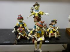 Six Pinocchio plaster or similar figures