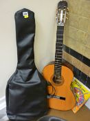Hohner acoustic guitar in a canvas case and a guitar workout book