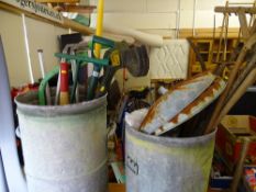 Two metal wastebins with quantity of long handled garden tools including strimmer E/T