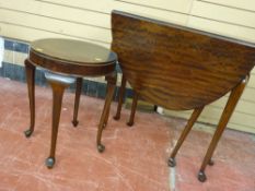 Polished wood compact drop leaf dining table on pad feet with a circular occasional table on pad