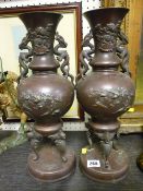 Pair of Oriental bronze vases on circular plinths