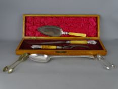 Victorian oak cased carver set, an EP basting spoon, cake slice and two sets of sugar tongs