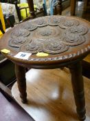 Small three legged milking stool with carved floral detail to top