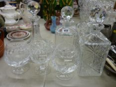 Ship's type decanter and two square decanters, all with stoppers, two brandy glasses and one other