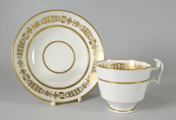 A SWANSEA PORCELAIN CUP & SAUCER gilt decorated with linking flowers, trumpets and circles,