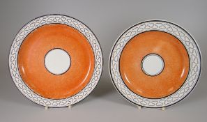 A PAIR OF SWANSEA POTTERY PLATES OF PLAIN FORM having a wide orange ground inner border, centred