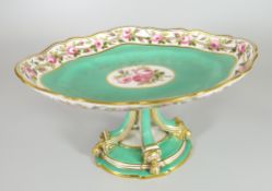 AN ENGLISH PORCELAIN CENTRE DISH of oval form and raised over four curved supports on shaped oval