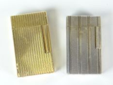 Two S T Dupont gas cigarette lighters - a machine turned white metal example and a ribbed yellow