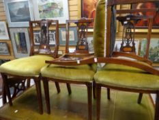 A set of four Edwardian inlaid mahogany and carved back bedroom chairs with stuff-over cushioned