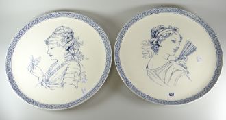 A pair of early twentieth century Wedgwood pottery chargers decorated with portraits of ladies in
