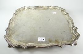 Large solid silver square tray or salver having pie crust edge, raised on four scroll feet,