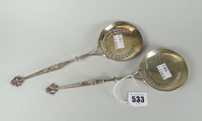 Pair of silver pierced possibly bon bon or nut spoons, having flat circular heads and dolphin