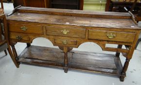 A nineteenth century oak Welsh dresser base having a configuration of three short drawers, a