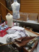 A vintage suitcase containing an 1860s deconstructed ladies dress, two small mannequins, vintage