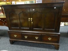 A nineteenth century dark oak mule chest with a base of three drawers, the facade converted to