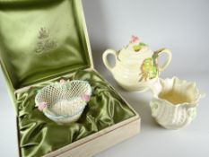 A cased Belleek porcelain basket having a powder blue rim and encrusted with three open pink