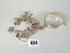 Silver bangle stamped 925 together with silver charm bracelet with assorted charms and heart