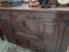A Jacobean-style panelled oak sideboard with metallic hinges & fittings, 102cms h x 160cms l x 50cms