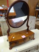A good antique toilet mirror of oval form with bow-front base having two drawers on bracket feet,
