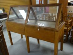A vintage oak retailer's display cabinet with top section in glazed triangular format, the base with