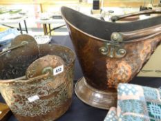 An oval based copper helmet coal scuttle with hammered body and swing handle and another Persian-