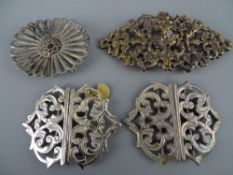 Four vintage nurse's buckles including two hallmarked silver, one white metal and a pierced bronze