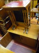 Teak G-Plan two door cupboard and a yew effect nest of three leather tooled top occasional tables