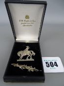 Two silver brooches in the form of a cowboy on a horse and a group of swimming dolphins