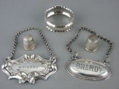 Two silver thimbles, one Charles Horner and a napkin ring along with two white metal decanter labels
