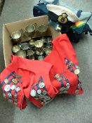 Two red and blue striped vests festooned with various fob pendants and medals in silver and other