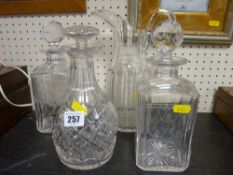 Three glass decanters with stoppers and an early jug