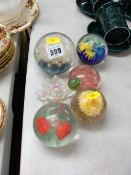 Five decorative glass paperweights and an ornamental flower