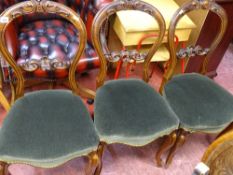 Three walnut balloon back dining chairs with carved detail