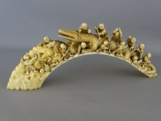 Circa 1900 well carved Japanese boar's tusk depicting a Komodo type reptile with many figures