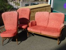 Vintage Ercol three piece suite comprising two seater settee and a pair of highback armchairs