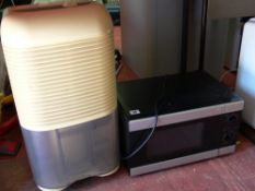 Household dehumidifier and a black coloured microwave oven E/T