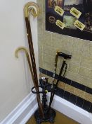 Black painted cast stickstand with a quantity of sticks