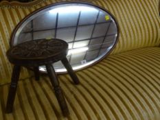 Mahogany bevelled oval wall mirror and a carved top milking stool