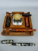 Antique polished inkstand with glass bottle (detachable lid) and two mottled effect fountain pens
