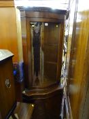 Polished wood corner cupboard with upper curved glazed single door and curved base cupboard