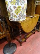 Oak drop leaf barley twist gate leg table and a turned column standard lamp with shade