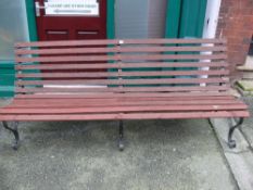 Wooden slatted garden bench with metal scrolled supports