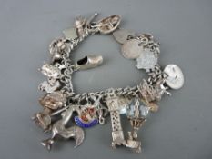 Silver charm and coin bracelet with approximately twenty two charms, 2.7 troy ozs (84 grms)