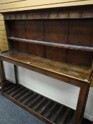 An eighteenth century mixed wood Welsh dairy dresser of simple plank form on tapered supports with