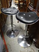 A pair of modern chrome and black leather effect top bar stools Condition reports provided on