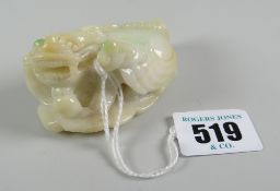 Believed Chinese jade toggle in the form of recumbent lion dog on rock work base, incised