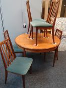 A vintage teak G-Plan circular extending dining table with five splat back and cushion seated