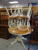 A good modern circular / oval extending dining table on cream supports and with four matching hoop-