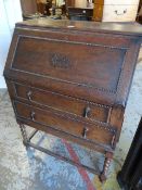 A vintage drop front bureau with two drawers on raised barley-twist legs together with a