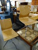 A pair of modern bent-wood chairs on chrome supports and a retro mosaic tile coffee table